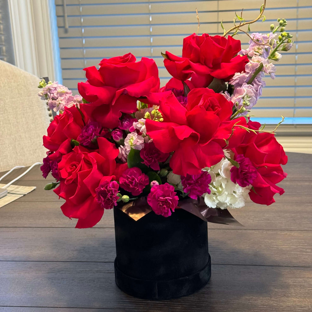 A luxurious bouquet featuring lush red roses in a romantic velvet box, designed for special occasions.